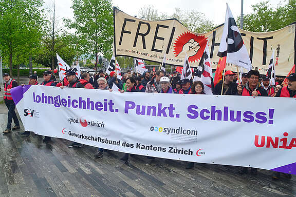 Front-Tansparent der SGB in Zürich: Lohngleichheit.Plunkt.Schluss