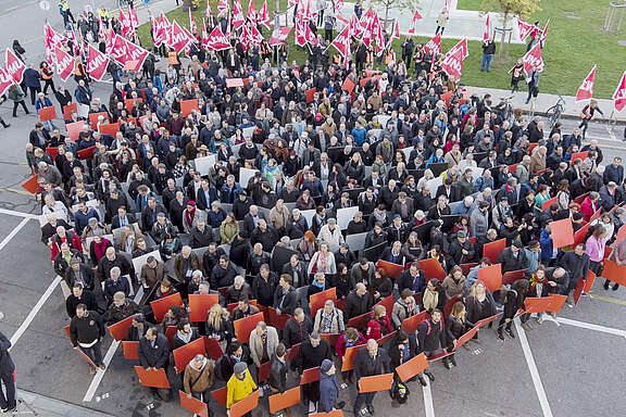 Grosse Gruppe von Unia-Mitgliedern stehen bereit für eine Aktion mit Schildern