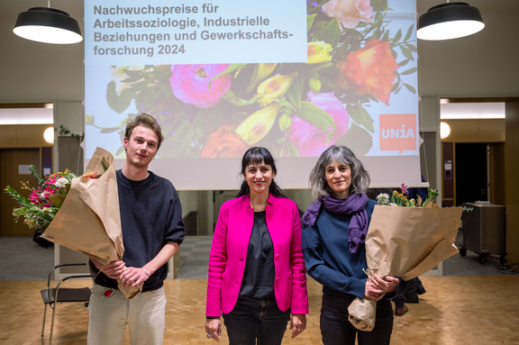 Dr. Sarah Baumann und Luc Ruffieux mit je einem Blumenstrauss und Vania Alleva in der Mitte