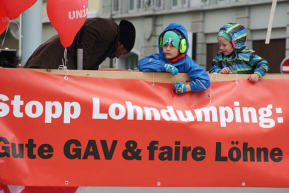 1.-Mai-Wagen mit Aufschrift: Stopp Lohndumping. Gute GAV und faire Löhne