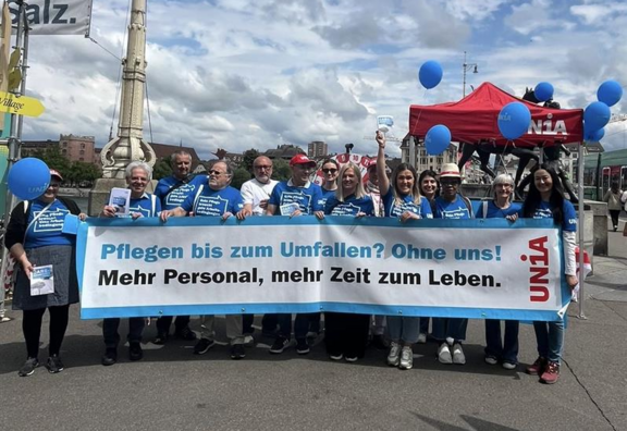 Assistenti e pensionati tengono in mano uno striscione di Unia su cui si legge: Assistenza fino allo sfinimento? Senza di noi! Più personale, più tempo per vivere.