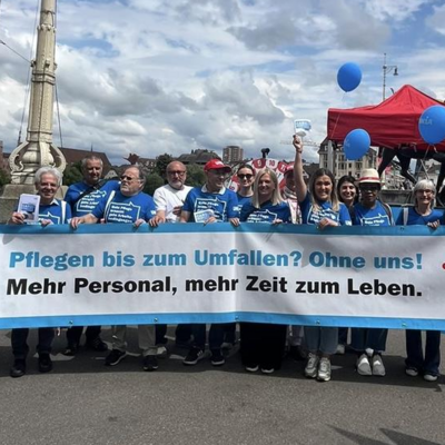 Care-Arbeiter:innen und Rentner:innen halten ein Unia-Transparent, auf dem wir lesen: Pflegen bis zum Umfallen? Ohne uns! Mehr Personal, mehr Zeit zum Leben.
