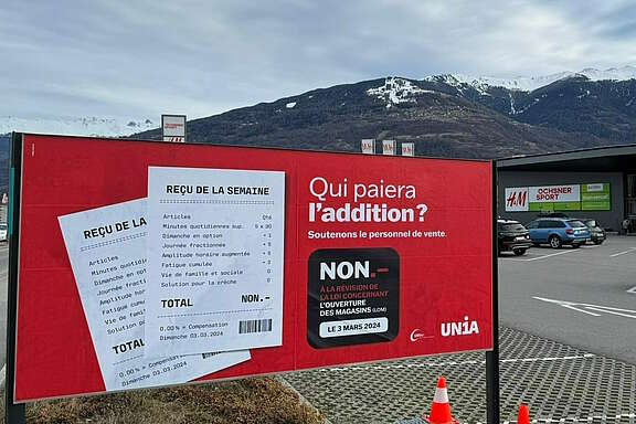 Manifesto in francese di colore rosso contro l'allungamento degli orari di apertura dei negozi nel Vallese