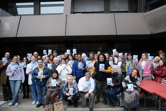Quarante membres de la branche des soins et de l’accompagnement d’Unia posent pour une photo de groupe et tiennent des exemplaires du Manifeste du Care dans les mains. 
