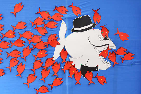 Affiche avec des petits poissons attaquants un requin