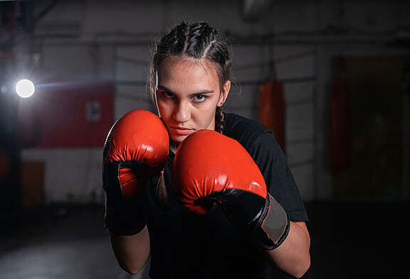 Jeune boxeuse portant des gants de boxe rouges