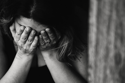 Frau versteckt ihr Gesicht (schwarz-weiss)