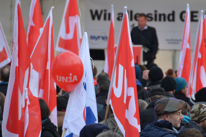 Le bandiere di Unia davanti a una tappa della manifestazione di protesta contro General Electric