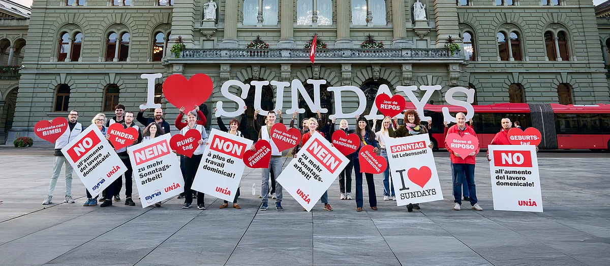 Un gruppo di persone mostra cartelli e grandi lettere che formano la scritta «I love Sundays».