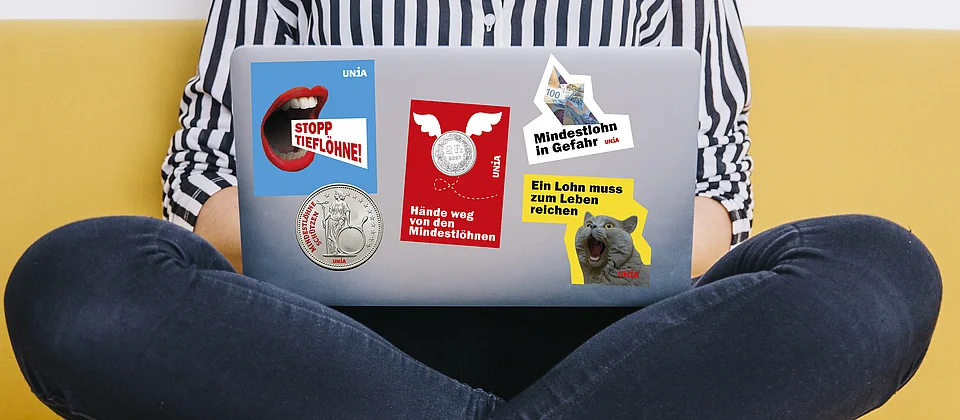 Laptop-Deckel mit fünf Unia-Stickern gegen tiefe Löhne: «Stopp Tieflöhne!», «Mindestlohn in Gefahr», «Hände weg von den Mindestlöhnen», «Mindestlöhne schützen» und «Ein Lohn muss zum Leben reichen».