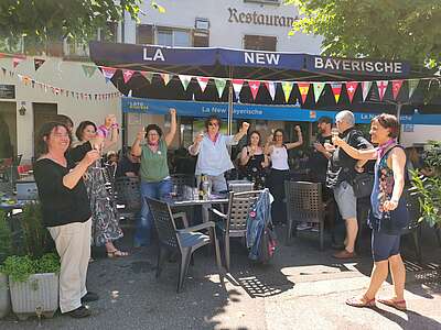Jurassierinnen freuen sich in einem Restaurant-Garten über den Erfolg ihrer Lohngleichheitsinitiative