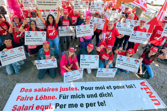 Des membres d'Unia issus du commerce de détail avec des casquettes Unisa et des t-shirts imprimés avec le slogan: il faut augmenter les salaires.
