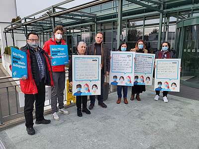 Reiniger:innen und Vertreter:innen der Unia mit Transparenten vor einem Gebäude