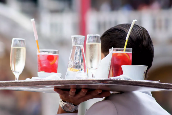 Un cameriere porta un vassoio con bicchieri