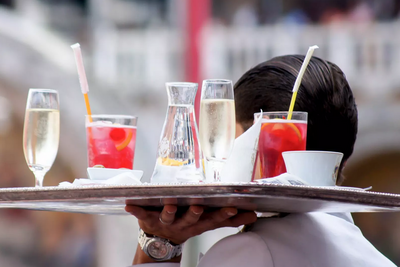 Un cameriere porta un vassoio con bicchieri