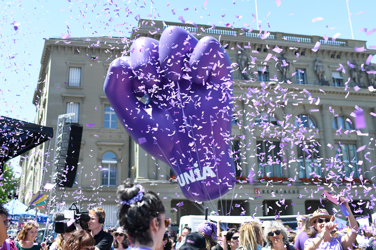 Grosse, violette Faust als Ballon mit lila Confetti, die in der Luft rumfliegen