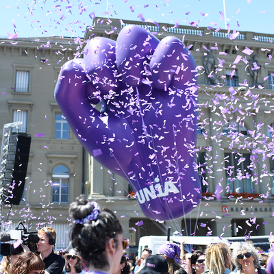 Grosse, violette Faust als Ballon mit lila Confetti, die in der Luft rumfliegen