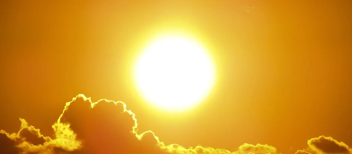 Sole accecante in un cielo arancione – immagine simbolica delle ondate di calore