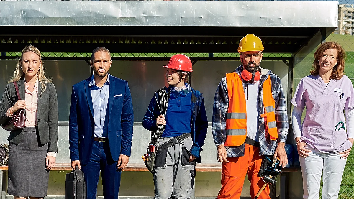 Cinq personnes se tiennent l'une à côté de l'autre: deux représentants commerciaux, une électricienne, un travailleurs de la construction et une soignante.