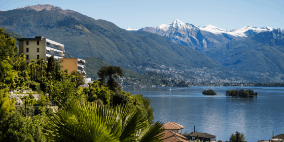 Um aldeamento turístico Reka, no Ticino, com vista para o lago e montanha.