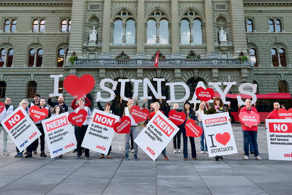 Eine Gruppe von Menschen halten Schilder und Buchstaben in die Luft, die den Schriftzug «I love Sundays» bilden.