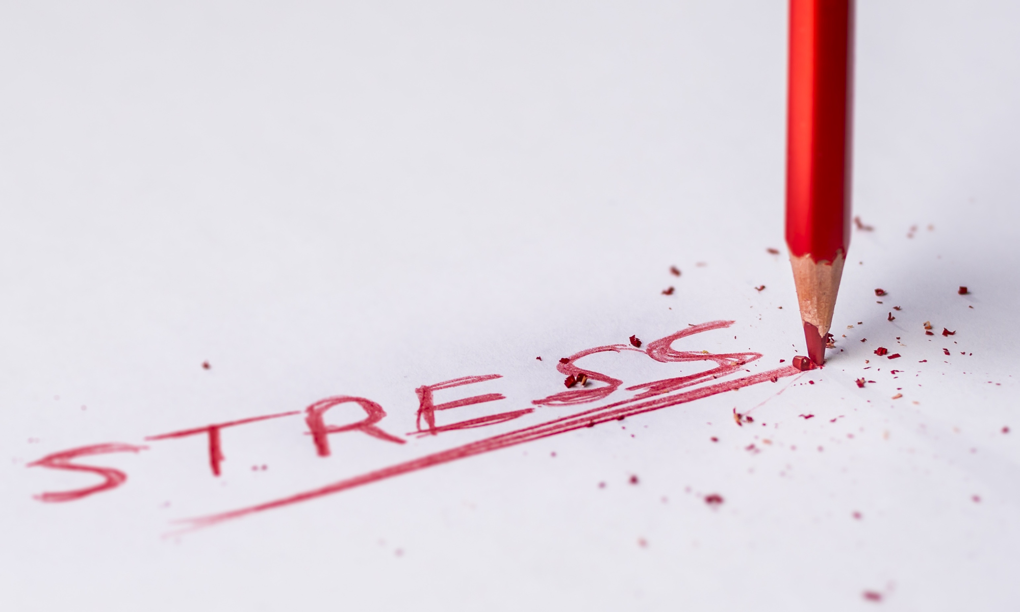 Ein roter Stift schreibt das Wort Stress