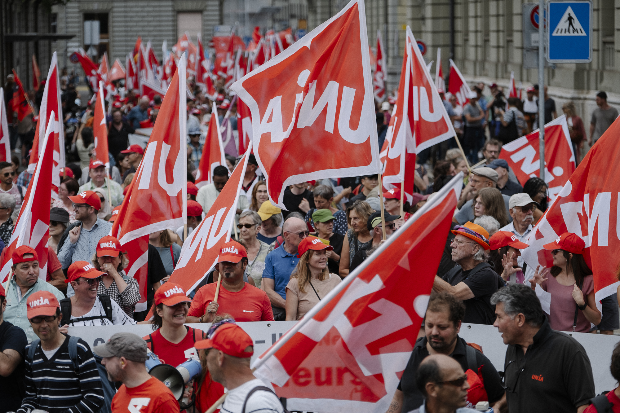 Molte persone con le bandiere di Unia alla manifestazione per i salari 2023