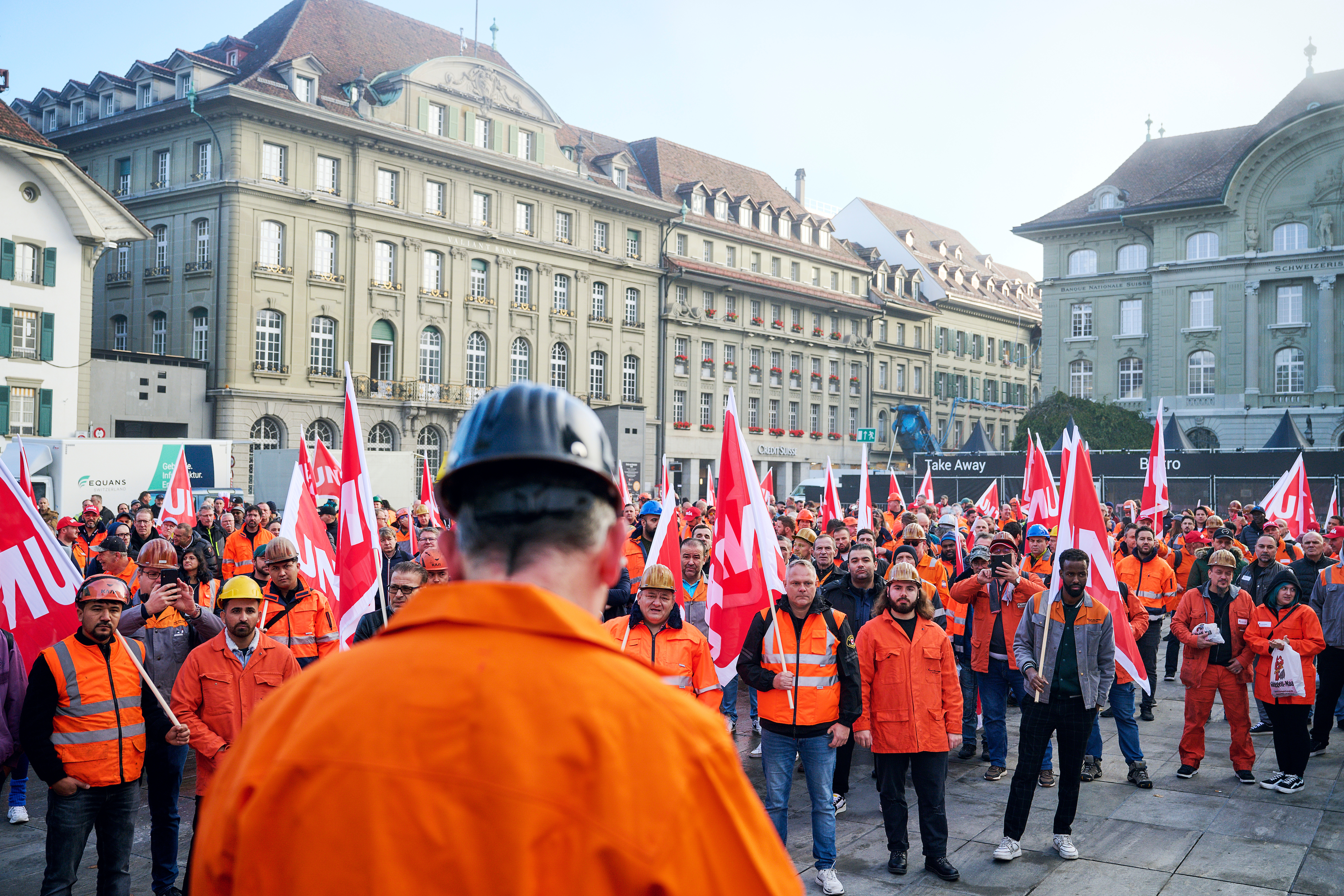 Einige der Arbeiter:innen von Stahl Gerlafingen in orangen Jacken und Westen an ihrer Kundgebung am 21. Oktober auf dem Bundesplatz in Bern