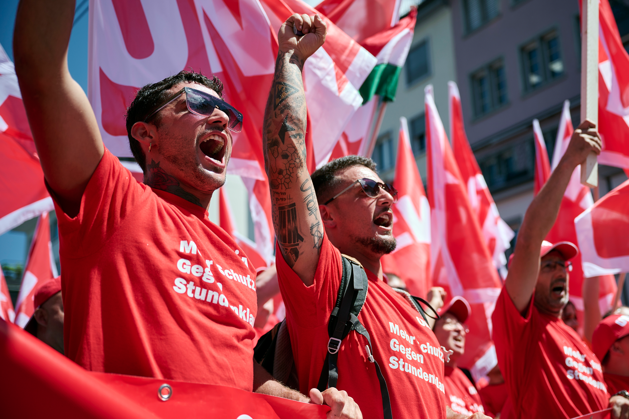 I lavoratori edili manifestano per un buon CNM e alzano i pugni in aria