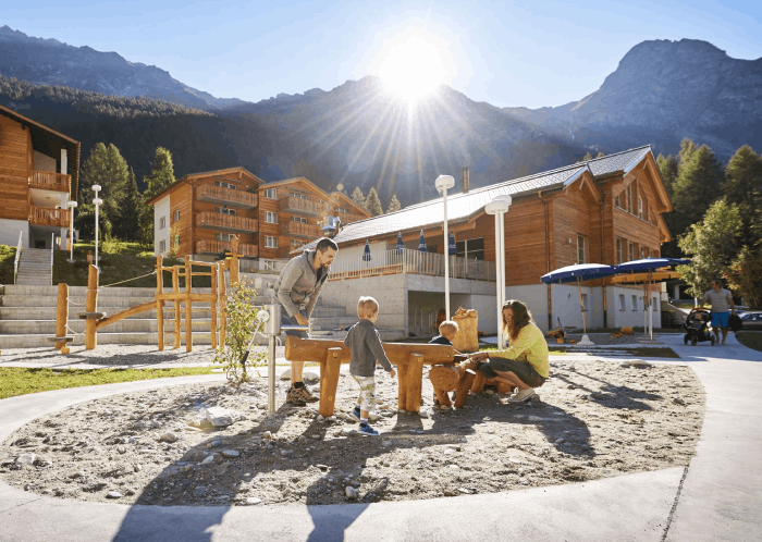 Eine Familie auf dem Spielplatz in einem Reka-Feriendorf in den Bergen