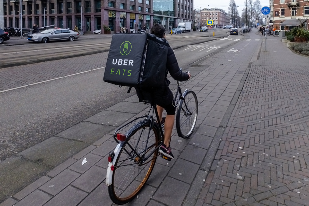 Person auf Velo mit Uber-Eats-Rucksack für Essensauslieferung