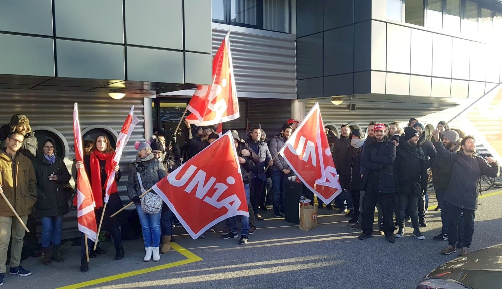 Angestellte mit Unia-Fahnen vor der Firma Symetis