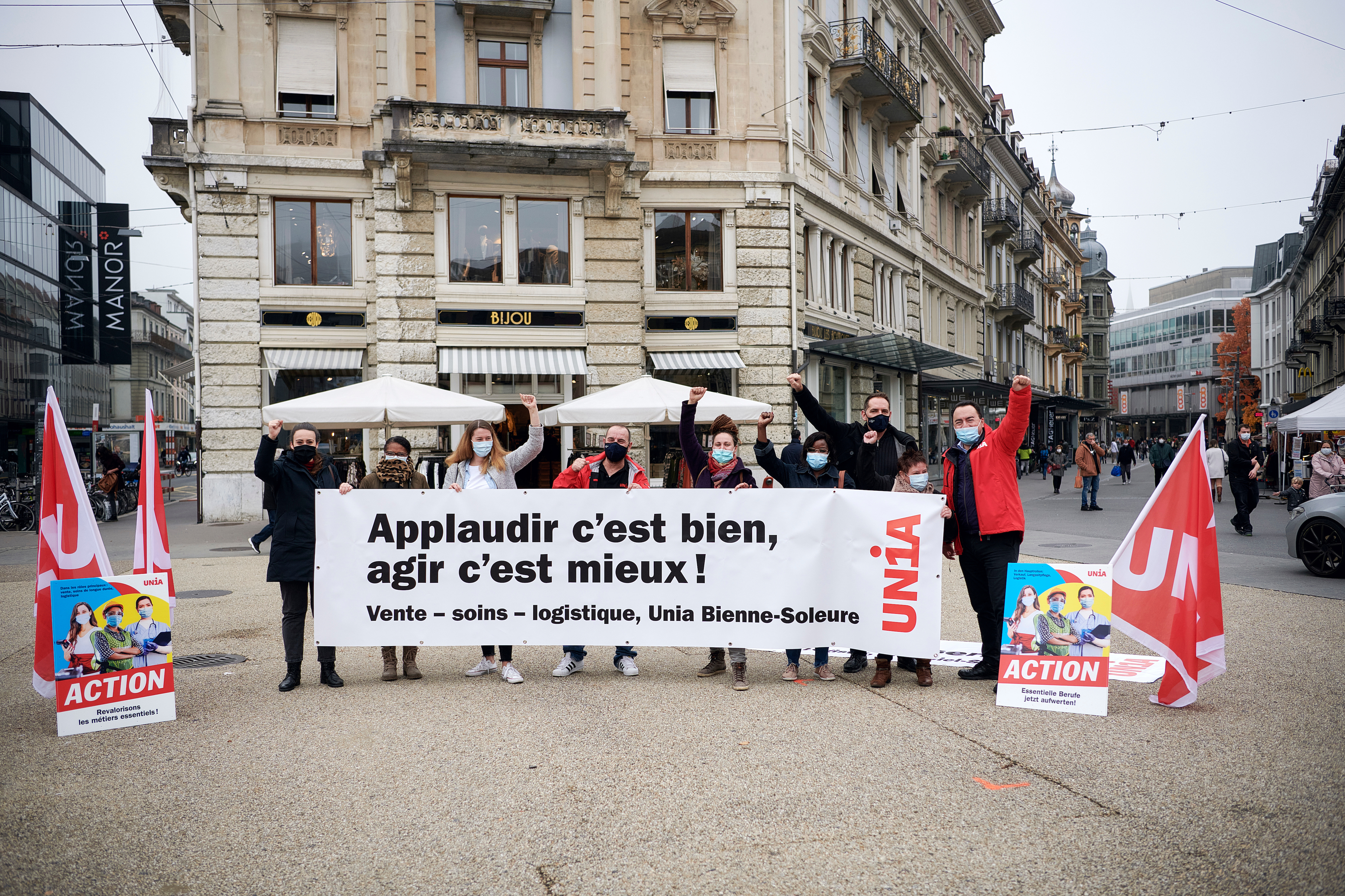 Action «Revalorisons les métiers essentiels» à Bienne. Neuf militant-e-s avec une banderole.