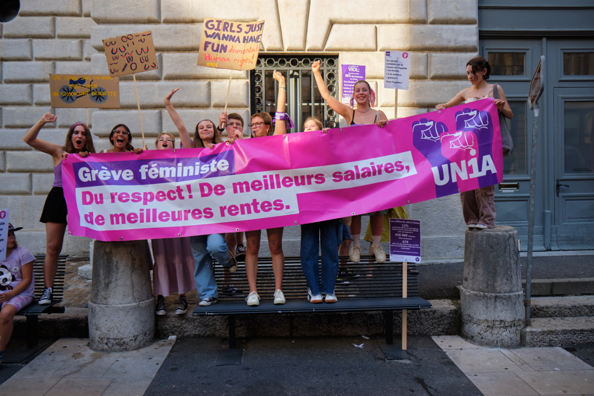 Des jeunes femmes derrière une banderole avec des revendications de la grève féministe