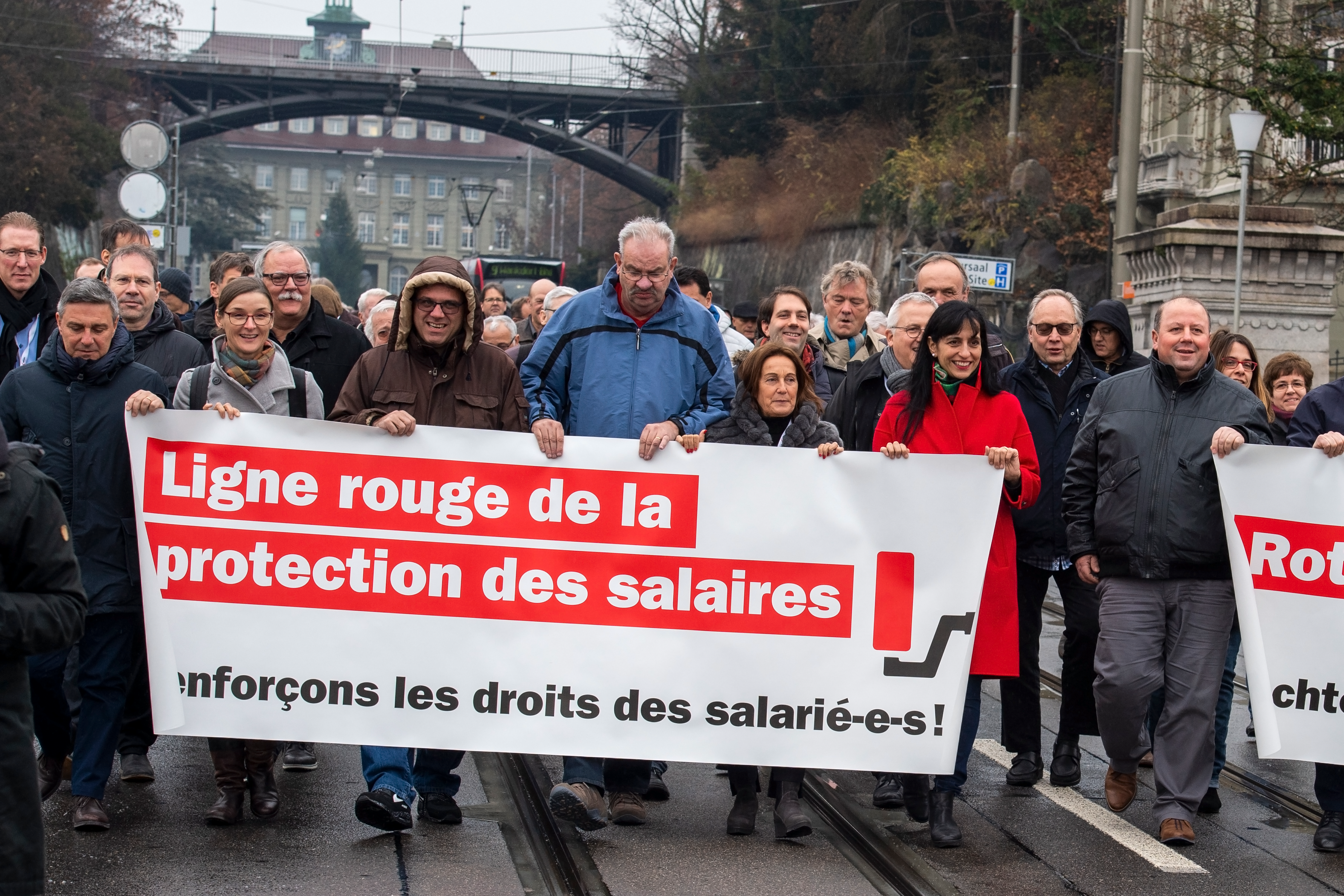 Manifestation syndicale à Berne. Un groupe de personnes, entre eux la présidente d'Unia, Vania Alleva, marche en tenant une banderole avec le message: "Ligne rouge de la protection des salaires – Renforçons les droits des salarié-e-s!"